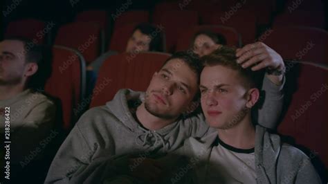 couple gays embracing in movie theater homosexual men embracing in