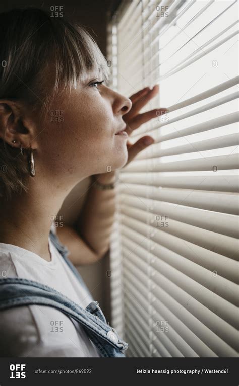 young woman   blinds   window stock photo offset
