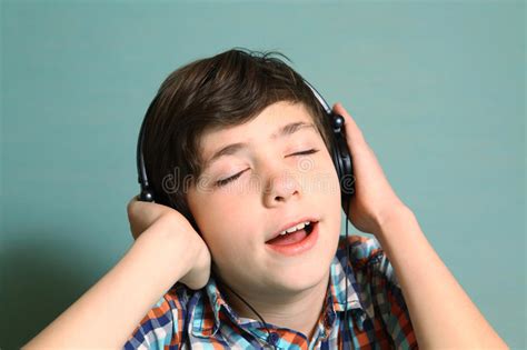 de jongen met hoofdtelefoons luistert aan populaire muziek