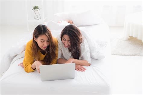 Asia Lesbian Lgbt Couple Lying On Bed Using Laptop Computer Together
