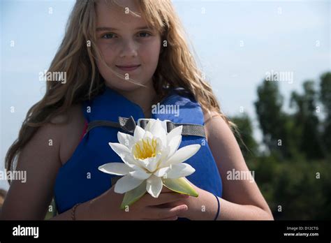 a girl wearing a lifejacket holds a white flower kenora ontario canada