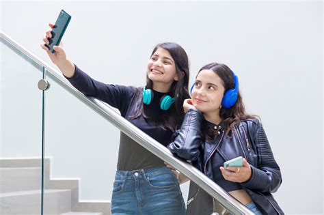 amigas latinas tomándose selfies en las escaleras foto de stock y más