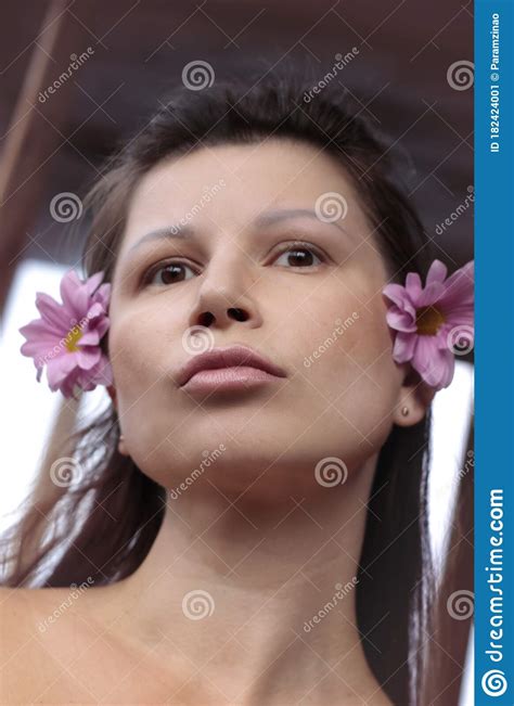 Portrait Of A Brunette Girl With Flowers Tanned Skin Brown Eyes