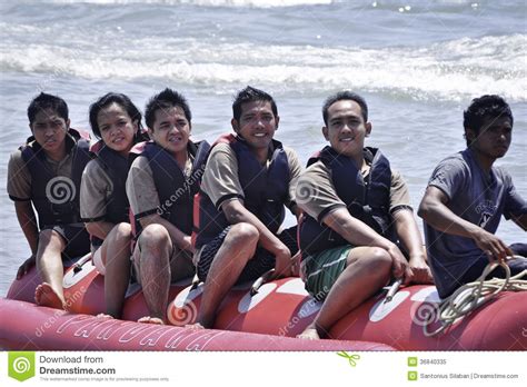 people riding on a banana boat in bali beach editorial