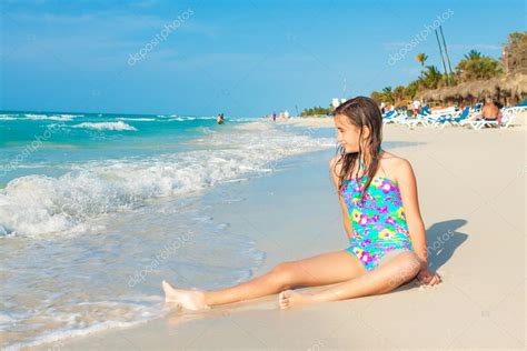 Cute Hispanic Teen Sitting On A Sunny Beach In Cuba