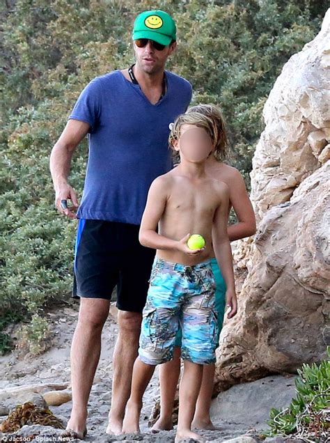 chris martin hits the beach for father son time with moses