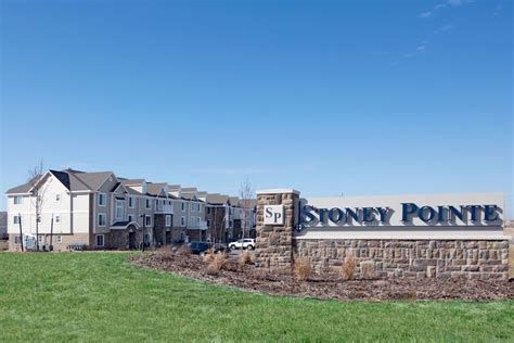sign  stoney point   front   buildings  green grass   sunny day