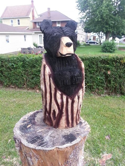 hand crafted chainsaw carved black bear in a log by parrish chainsaw