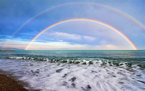foto dubbele regenboog boven zee