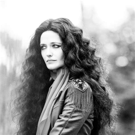 A Black And White Photo Of A Woman With Long Curly Hair Wearing A