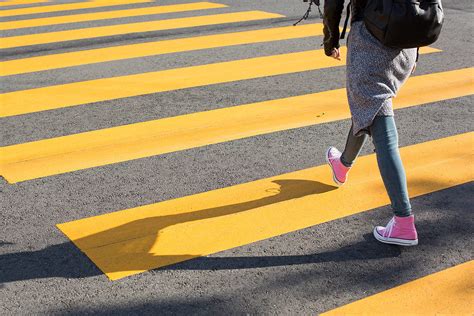 girl crossing street   yellow crosswalk  stock photo picjumbo