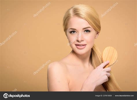 beautiful naked blonde girl brushing hair wooden hairbrush smiling