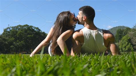 Young Couple Lying On Green Grass In Park And Relaxing Man And Woman