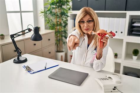 Middle Age Blonde Gynecologist Woman Holding Anatomical Model Of Female