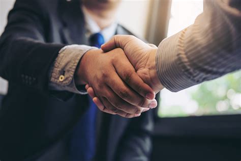 Two Business Men Shaking Hands During A Meeting To Sign Agreement And