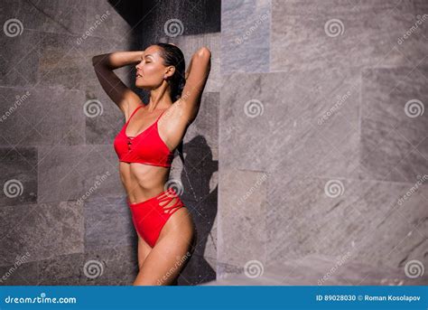 una giovane donna sexy che porta costume da bagno rosso che inonda