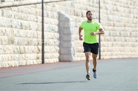 photo  muscular sporty man running  road