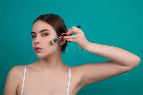 Young Woman Applying Foundation Powder Or Blush With Makeup Brush
