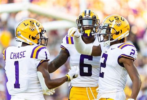 lsu football players standing   sidelines   hands