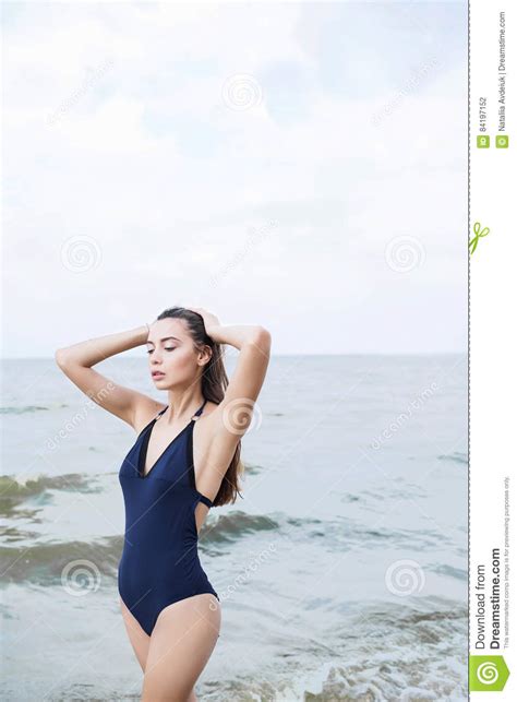 Woman With Long Dark Hair In A Piece Blue Bathing Suit On