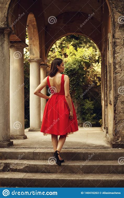 portrait of beautiful woman wearing red classy dress view
