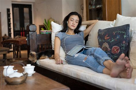 singaporean woman on her sofa relaxing by stocksy contributor eyes