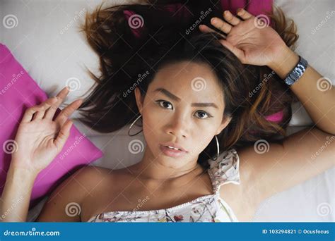 Portrait Of Young Attractive And Beautiful Asian Woman Lying On Bed At