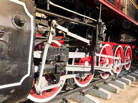 groot ijzer wielen van een rood en zwart trein staand aan rails en suspensie elementen met veren