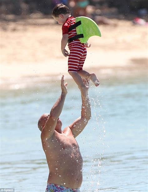 kai rooney splashes about in the water on barbados beach