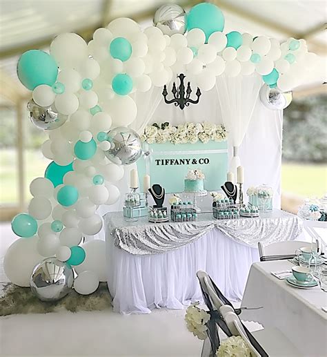 a table topped with lots of white and blue balloons