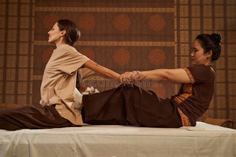 Thai Masseuse Stretching Client During Massage Session Stock Image