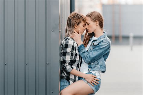 schöne junge lesbische paar umarmen und küssen im freien stockfoto und