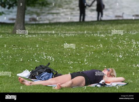 london uk st june   woman sunbathing  hyde park   warm sunny day   capital