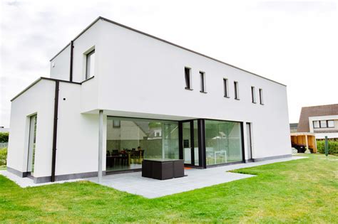 nieuwbouw moderne villa witte crepi beglaasde achtergevel zwart buitenschrijnwerk compact