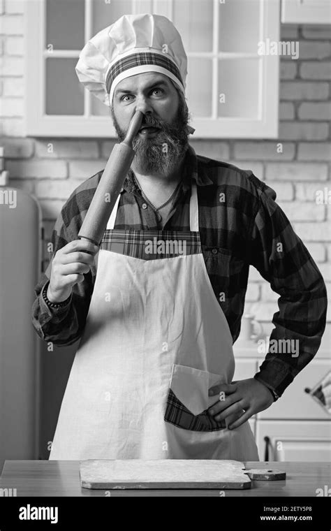 chef barbudo pega un rodillo en su nariz chef loco en una cocina