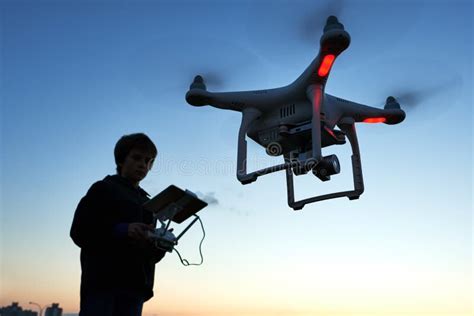 young man operating  flying drone  sunset stock photo image  motion sunset