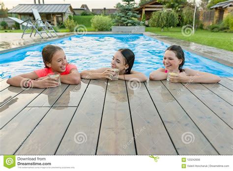Three Happy Girls With Beverages On Summer Party In The Swimming Pool