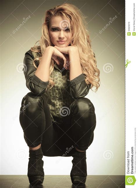 Woman In A Crouched Position Smiling To The Camera Stock