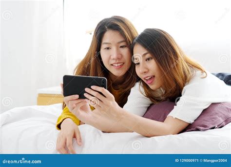 Young Cute Asia Lesbian Couple Using Smart Phone With Happiness Stock