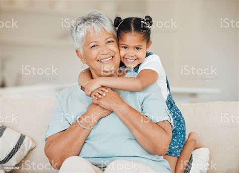 Shot Of A Grandmother And Granddaughter Bonding On The Sofa At Home