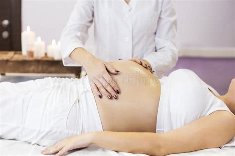 pregnant woman have massage treatment at spa salon stock