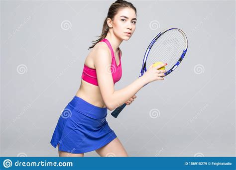 Portrait Of Female Tennis Player Serving Ball Isolated On Gray