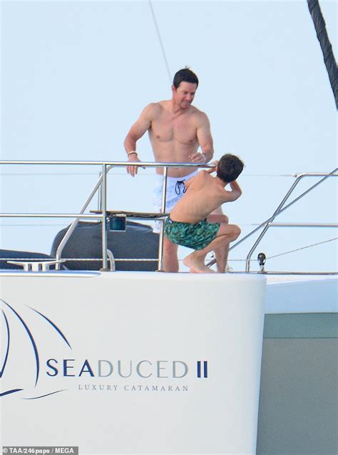 mark wahlberg shows off ripped abs as he takes bikini clad