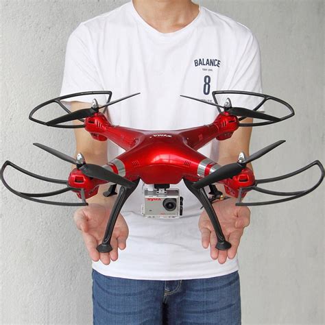 man holding   red  black remote controlled flying device  front   face