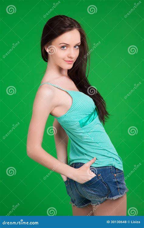 portrait of beautiful brunette girl wearing shorts and green stock