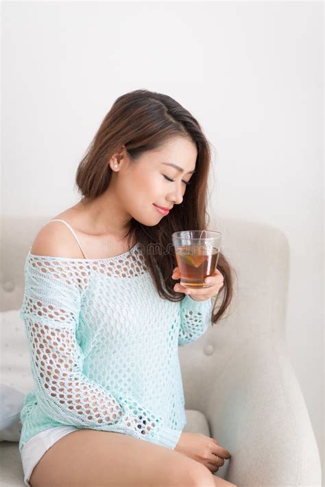Beautiful Young Asian Woman Drinking Her Morning Tea Over A Breakfast