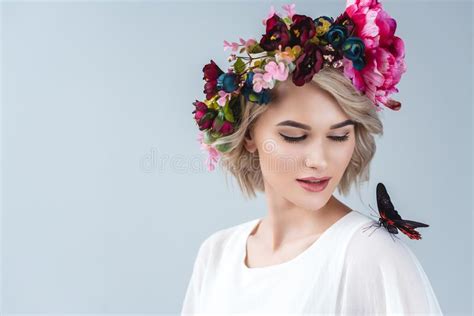 beautiful model posing in floral wreath with butterfly on