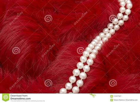 A Photo Of The Elegant Pearl Necklace On The Deep Red Fur