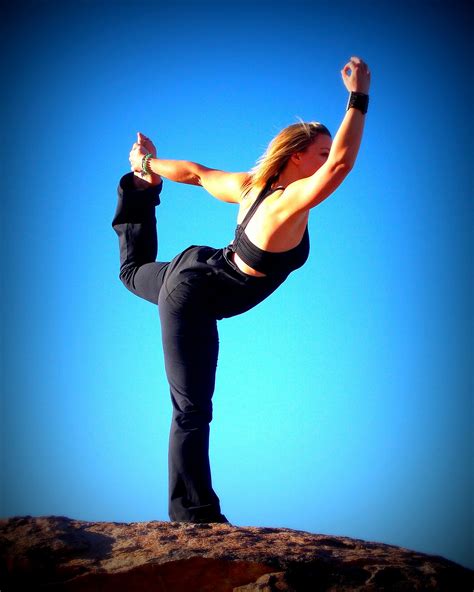 healthy woman doing yoga outdoors balancing dancer s pose
