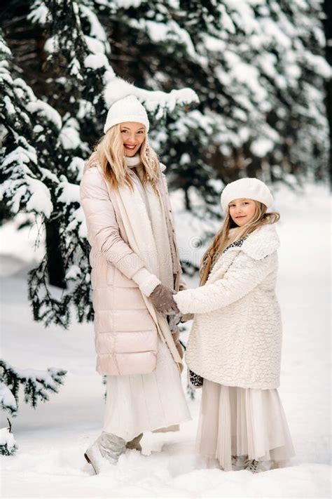 handsome mother and daughter are having fun outdoor in winter time